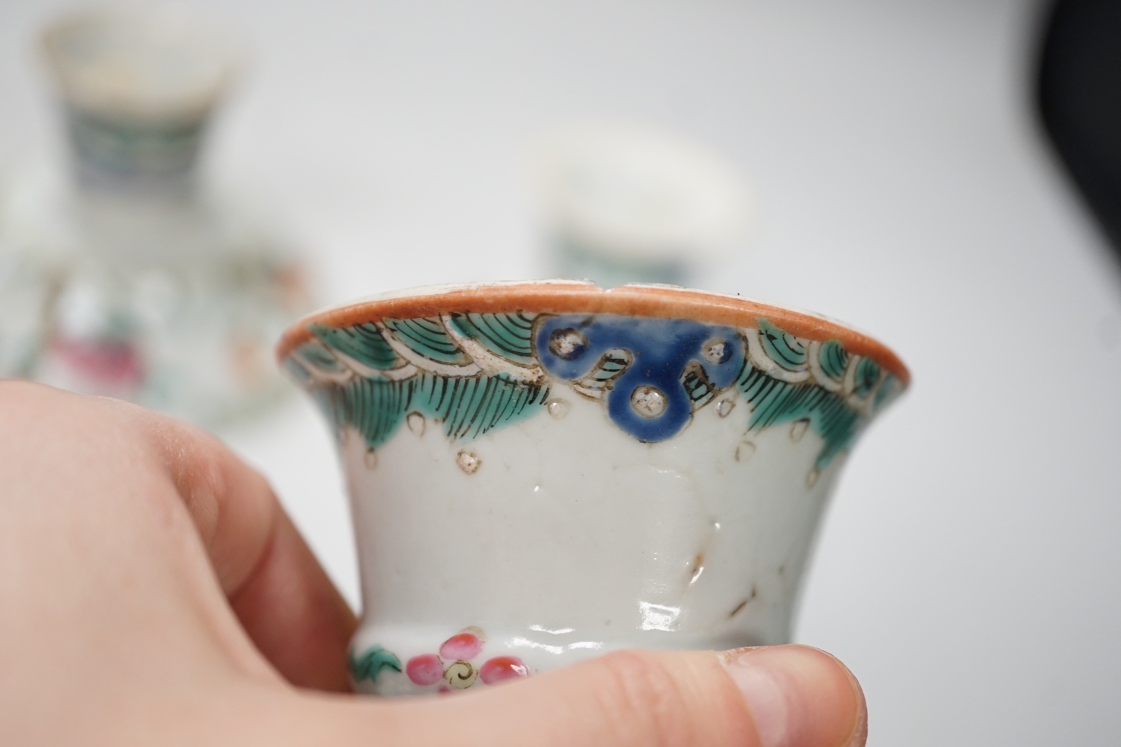 Three 19th century Chinese famille rose pedestal stem bowls, each painted with flowers and foliage, 9.5cm tall